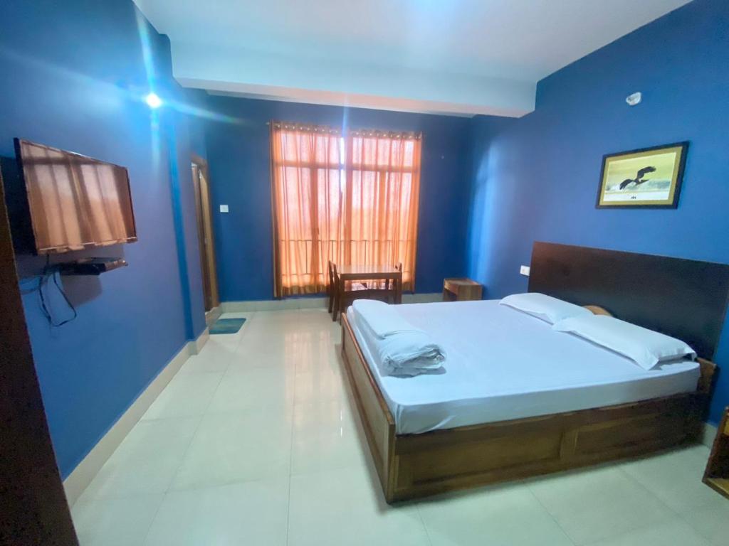 1 dormitorio con 1 cama en una habitación azul en Chief Guest House, en Āīzawl