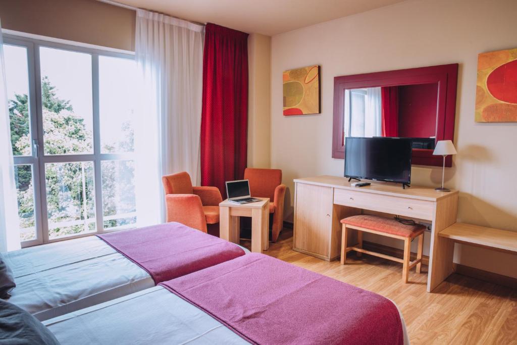 A television and/or entertainment centre at Hotel Arha Mar Comillas