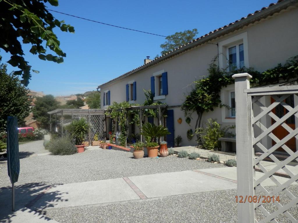 een huis met een poort en een binnenplaats met potplanten bij Maison de Laura in Salsigne