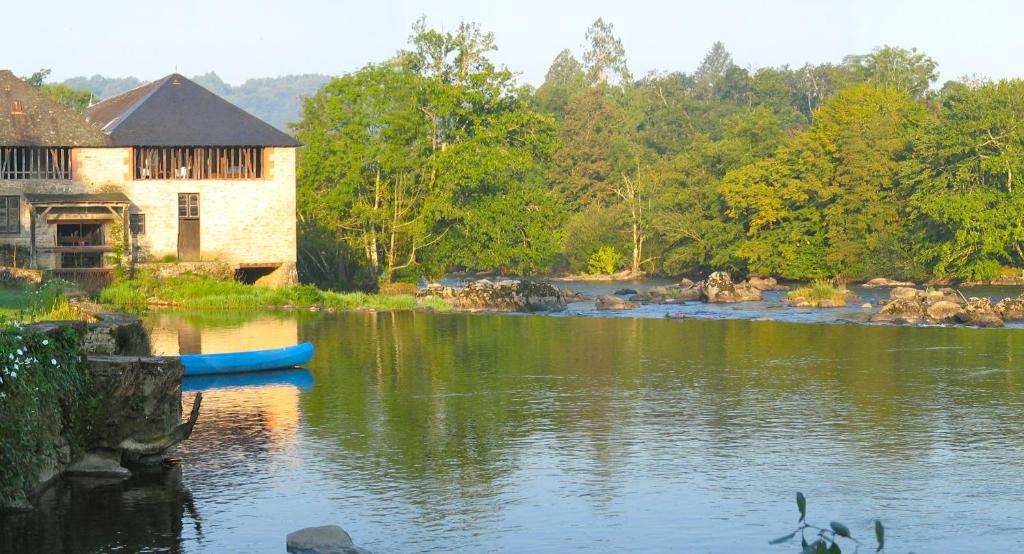 um edifício ao lado de um rio em Moulin du Daumail em Saint-Priest-sous-Aixe