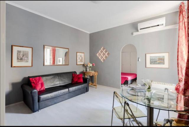 a living room with a black couch and a glass table at VIA VENETO SUITE 529 in Rome