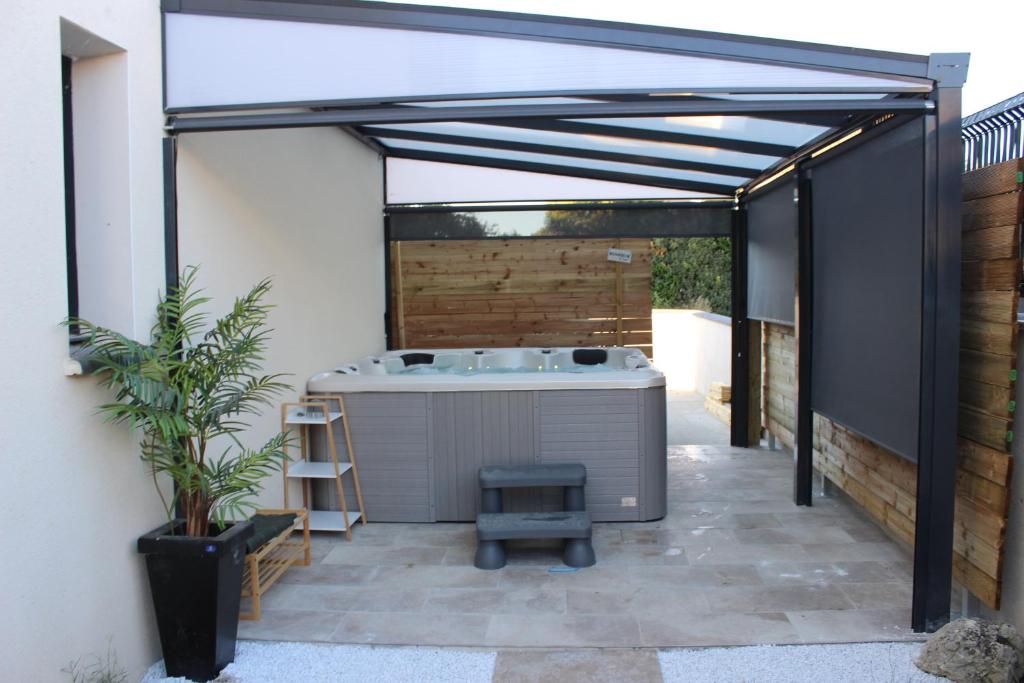 - une terrasse avec un bain à remous dans un bâtiment dans l'établissement Villa des rives du Lac, à Montans