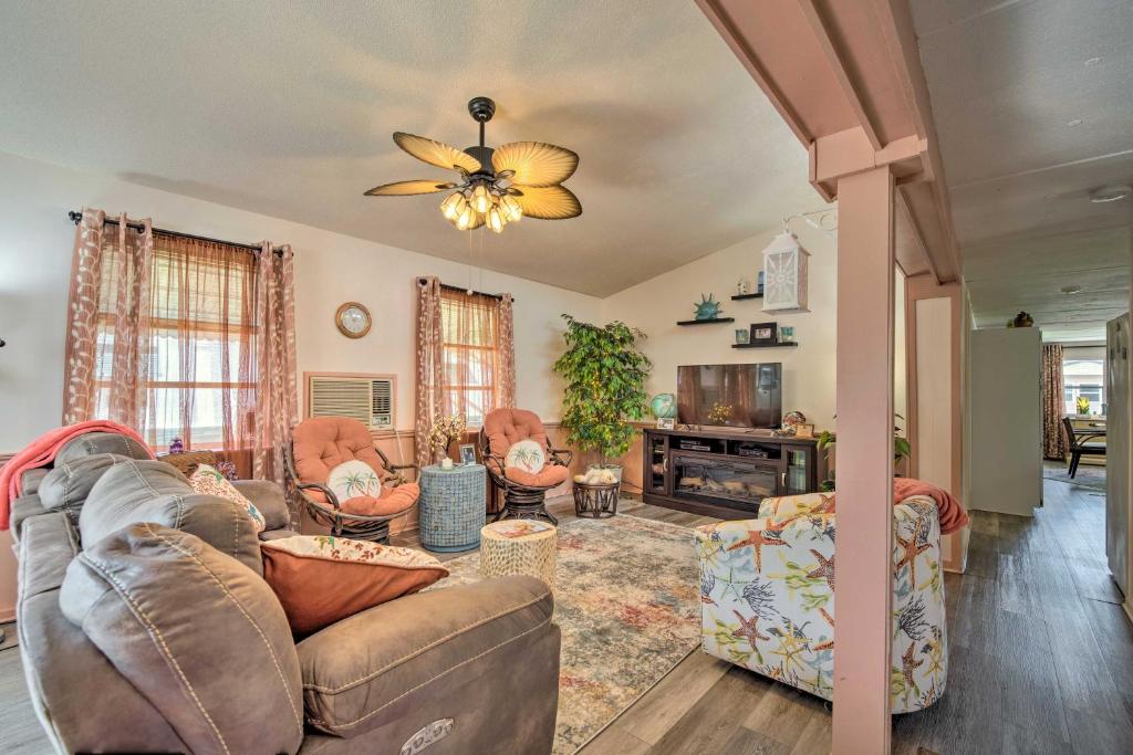 a living room with couches and a ceiling fan at Homosassa Retreat with Sunroom and Canal Views! in Homosassa