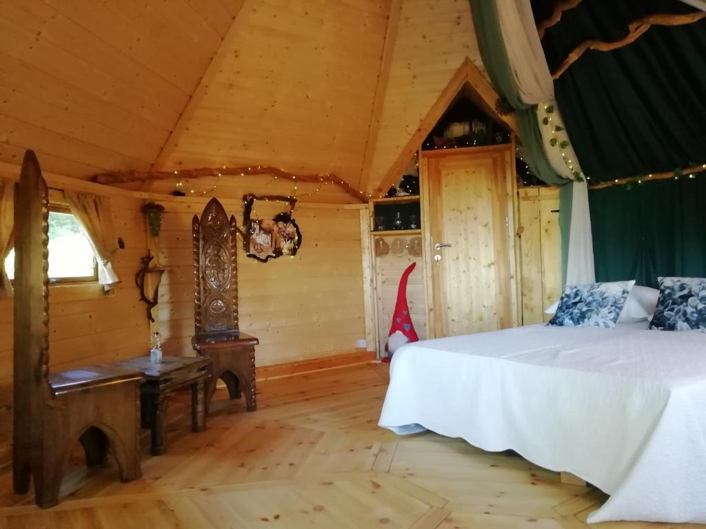 een slaapkamer met een bed en een bank in een kamer bij La Chaumière des Elfes in Servas