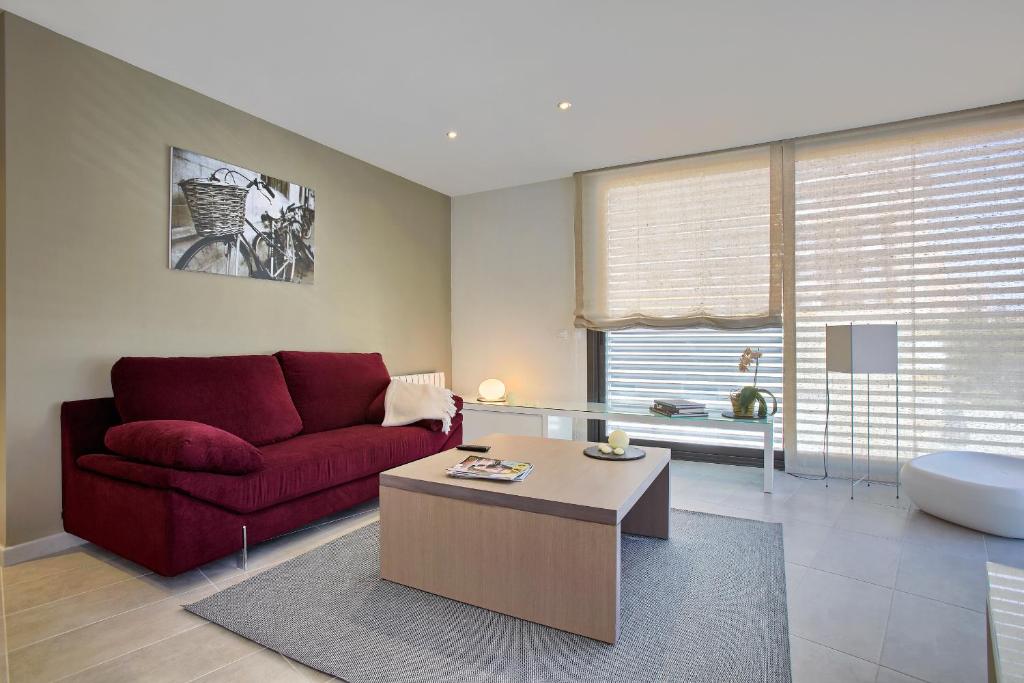 a living room with a red couch and a coffee table at Apartaments Terraza Figueres in Figueres