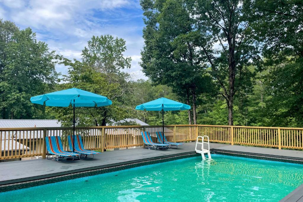 einen Pool mit blauen Stühlen und Sonnenschirmen in der Unterkunft McDonough Getaway with Private Lake on 24 Acres in McDonough