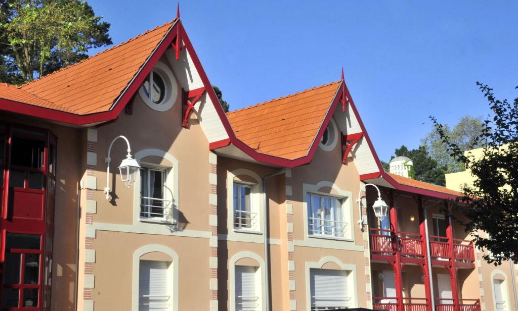 un gran edificio con techo naranja en Lagrange Vacances - Résidence Jardin Mauresque, en Arcachon