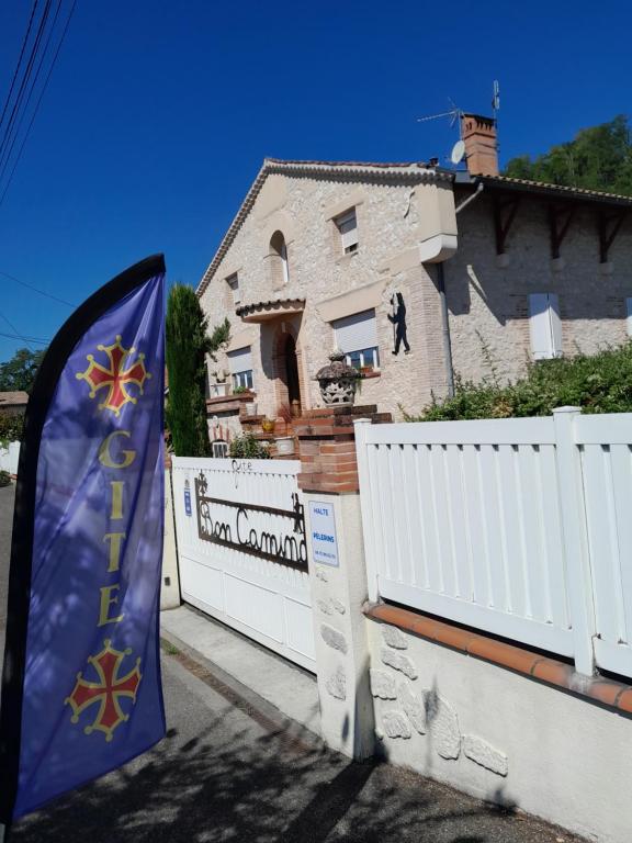 una bandiera su una recinzione di fronte a una casa di Bon camino a Moissac