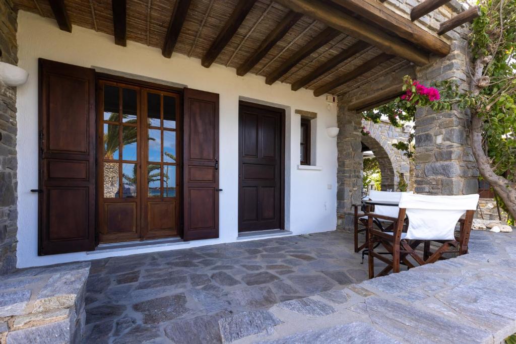 a patio with a wooden door and a table and chairs at Sunset Pounda in Pounda