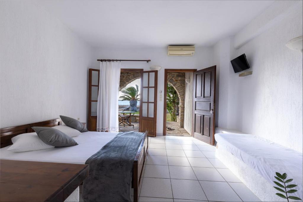 a bedroom with two beds and a door to a patio at Sunset Pounda in Pounda