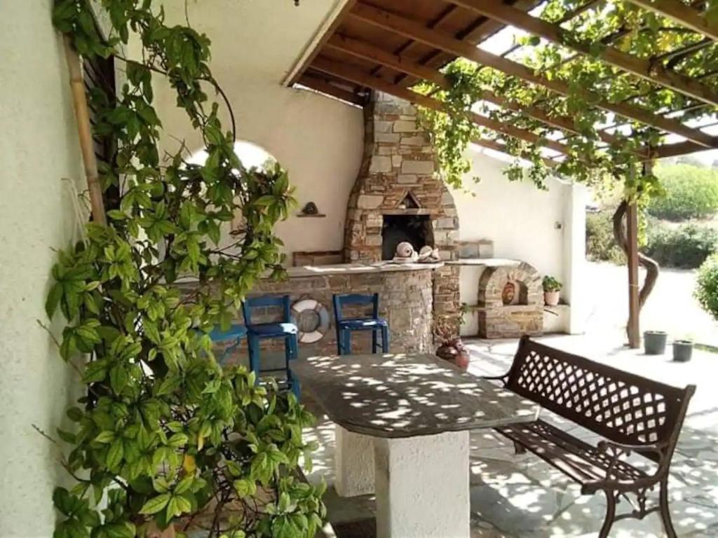 een patio met een tafel en een stenen open haard bij Evia Escape in Vathírrevma