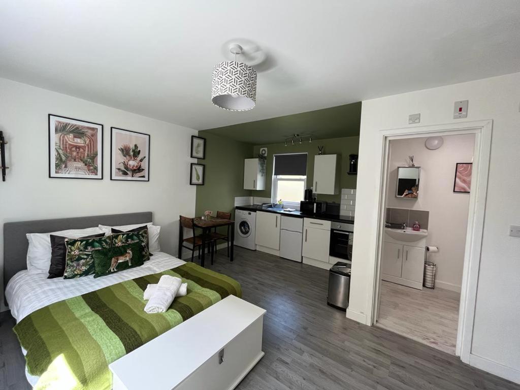 a bedroom with a large bed and a kitchen at The Green Room - Worthing in Worthing