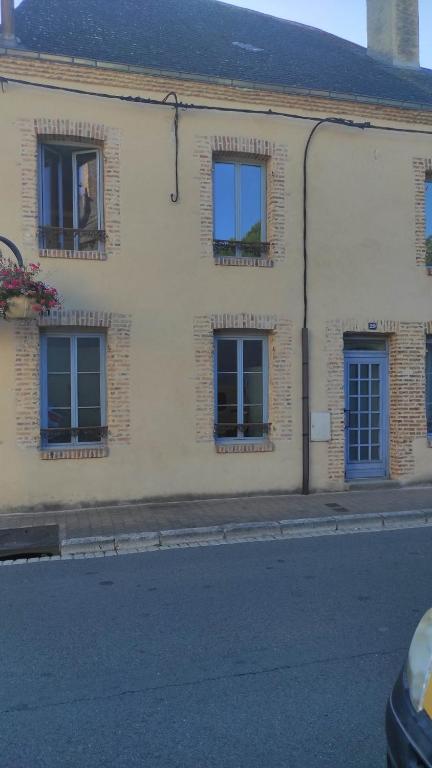 un edificio blanco con ventanas azules en una calle en AUBIGNY SUR NERE, en Aubigny-sur-Nère