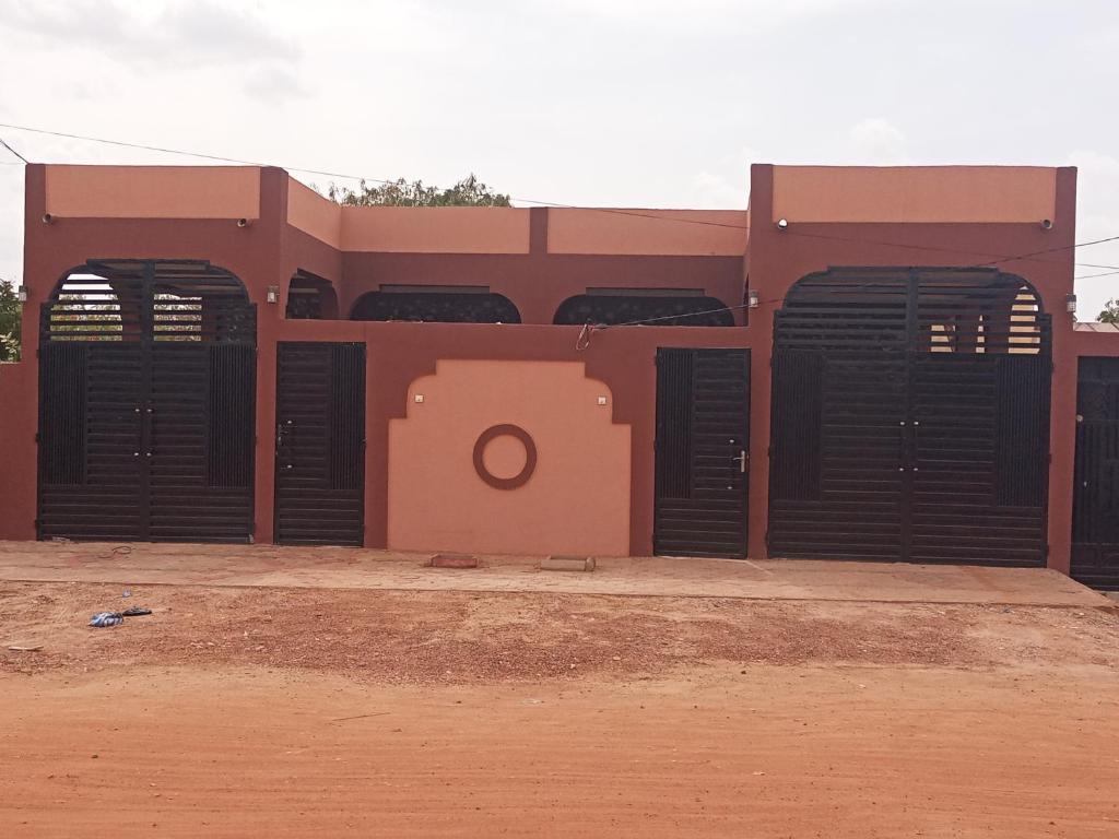 a building with black doors on the side of it at Résidence Lynda Prestige in Ouagadougou