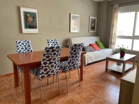 - un salon avec une table, des chaises et un canapé dans l'établissement Apartamento en la playa, à Les Cases d'Alcanar