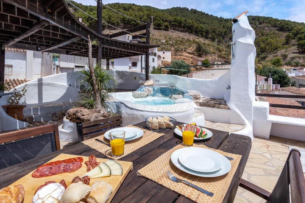 un tavolo con cibo e bevande su un patio con piscina di Town house with roof terrace and plunge pool ad Alcaucín