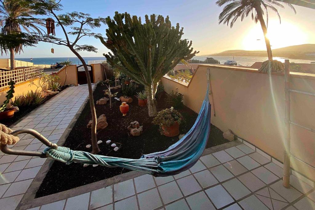 eine blaue Hängematte im Garten auf dem Balkon in der Unterkunft BEACH FRONT GRANILLO - ocean view, garden, bright and comfortable, Wi-Fi in Costa Calma