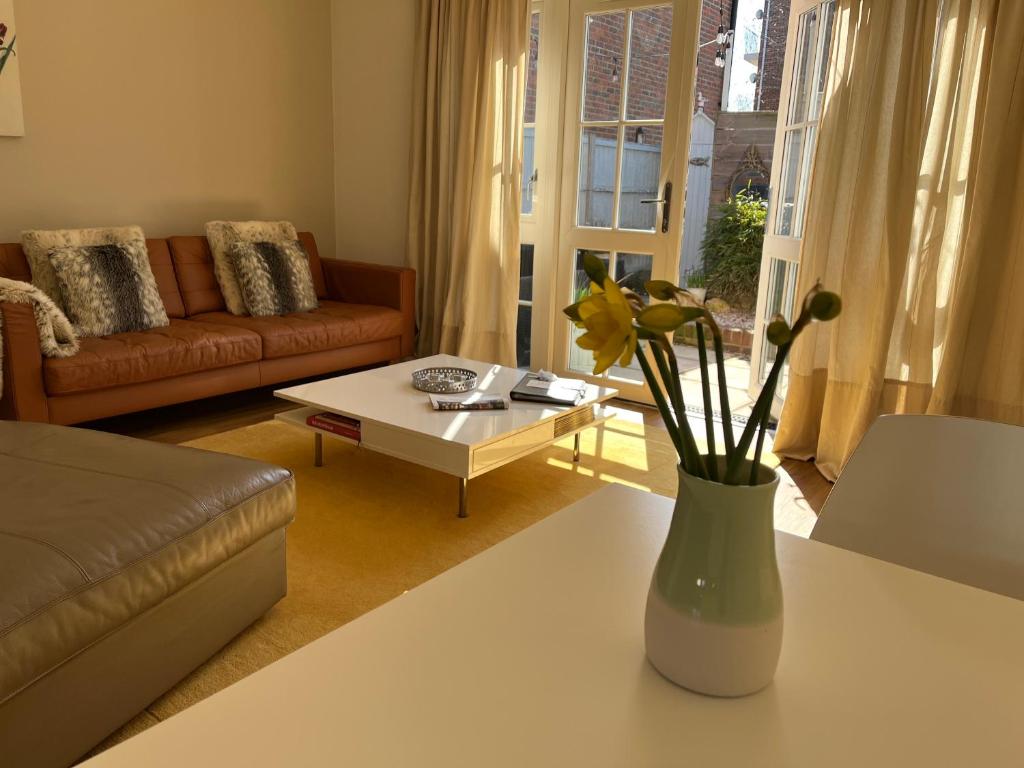 a living room with a vase with flowers on a table at Whitstable The Jolly in Whitstable