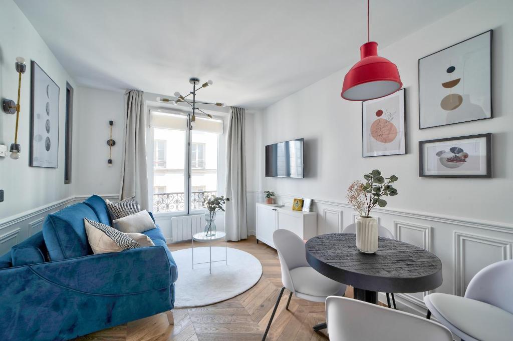 salon z niebieską kanapą i stołem w obiekcie Sublime appartement au coeur de Paris w Paryżu