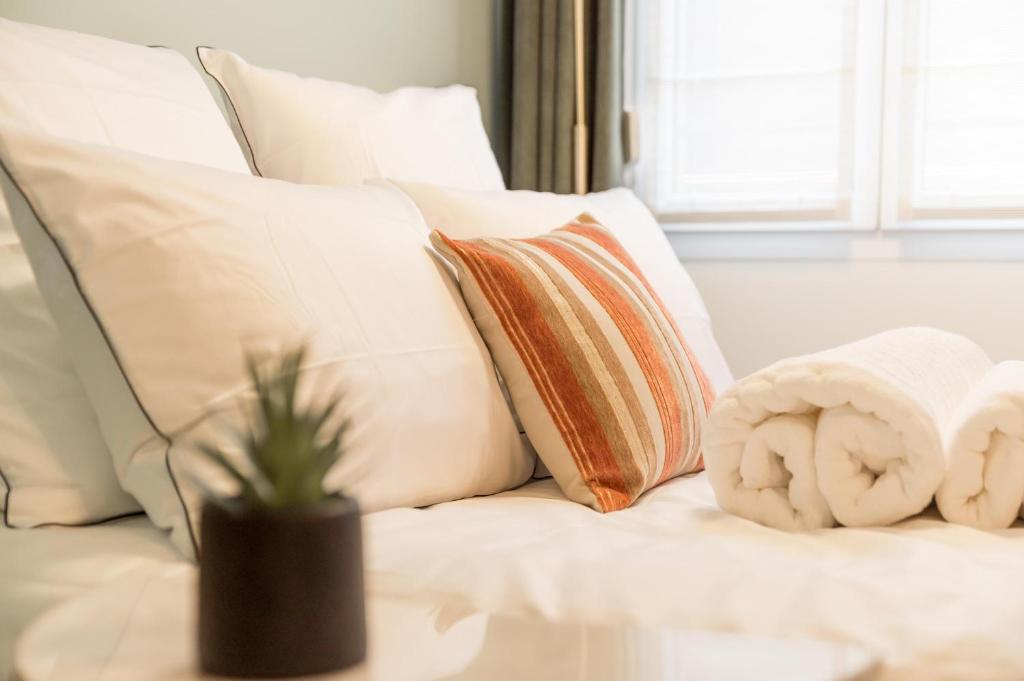 a white couch with pillows and a plant on a table at Relax And Go - Strasbourg Train Station in Strasbourg