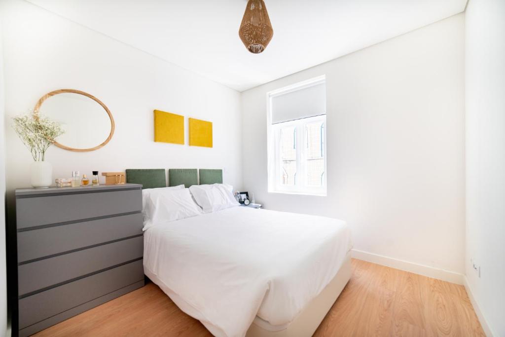 - une chambre avec un lit blanc et un miroir dans l'établissement Monsanto Hill House - NO. 565 1E, à Lisbonne