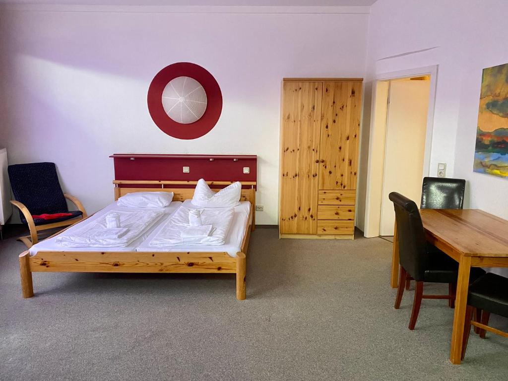 Pension Sassnitz Atelierhaus في ساسنيتز: غرفة نوم بسرير وطاولة طعام
