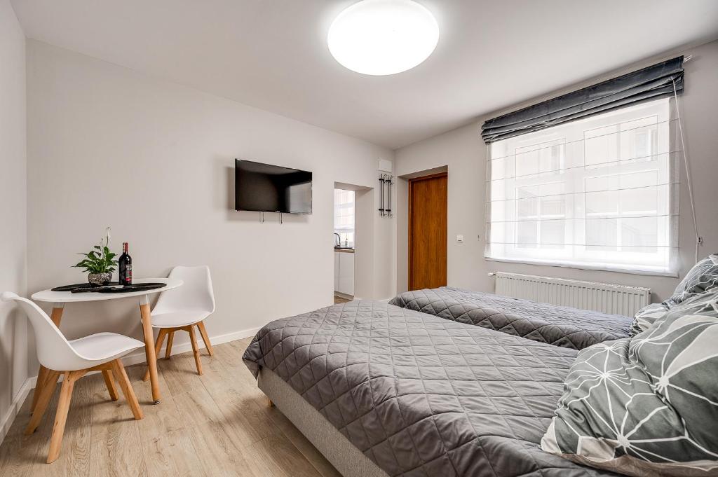 um quarto com uma cama e uma mesa com cadeiras em Central Platinum Apartments 20 em Rybnik