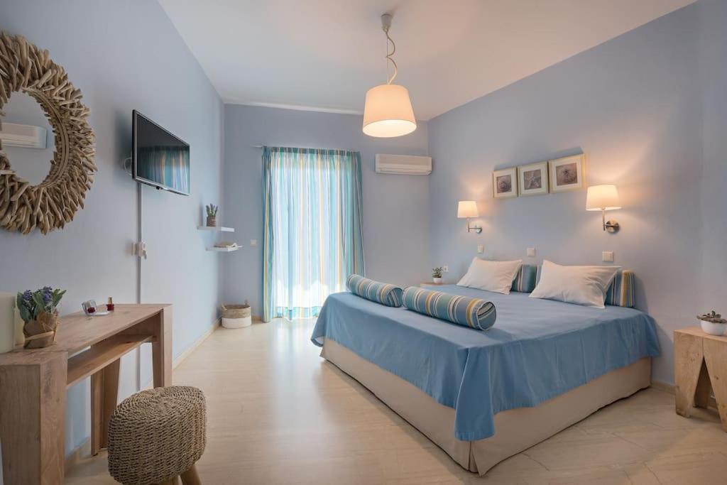 a blue bedroom with a bed and a table and a chair at Stella in the Village - Junior Studio Sea View in Plakias