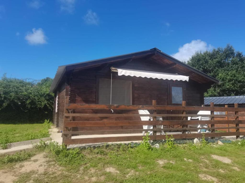 a wooden cabin with a window in a field at Chalet 35m2 Domaine du vieux chêne in Bergerac