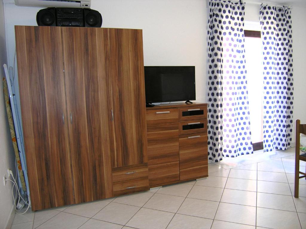 duże drewniane centrum rozrywki z telewizorem w obiekcie Apartments Murgic w Krku