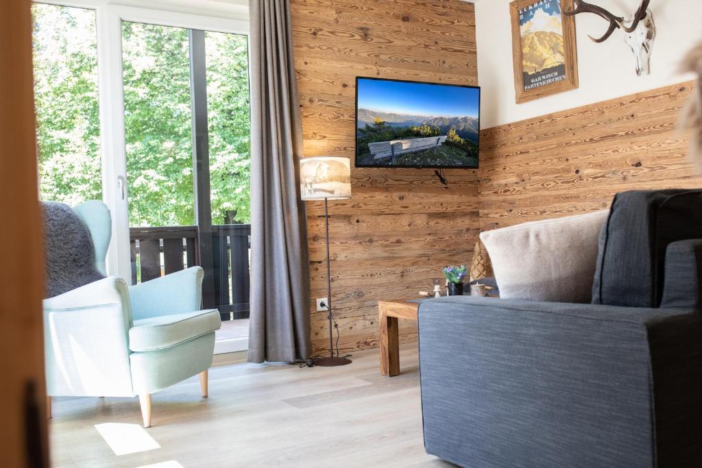 ガルミッシュ・パルテンキルヒェンにあるAlpennestの木製の壁にテレビ付きのリビングルーム