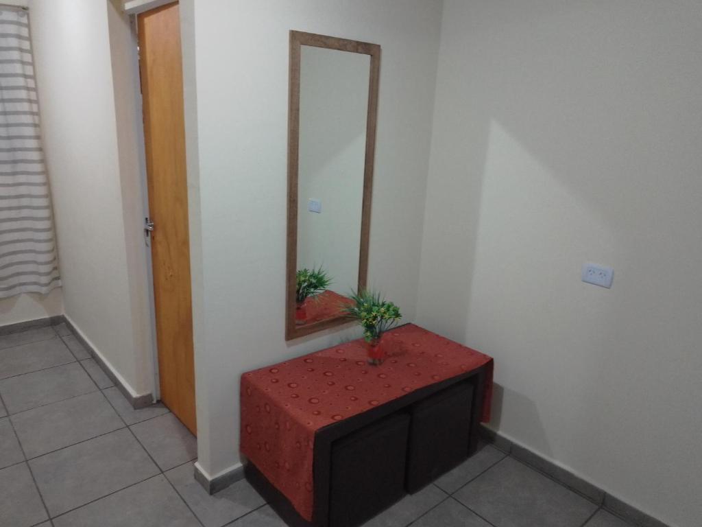 specchio e tavolo rosso in una stanza di Habitación amplia con baño privado - sin aire acondicionado con ventiladores - Serena Alojamientos a Villa Constitución