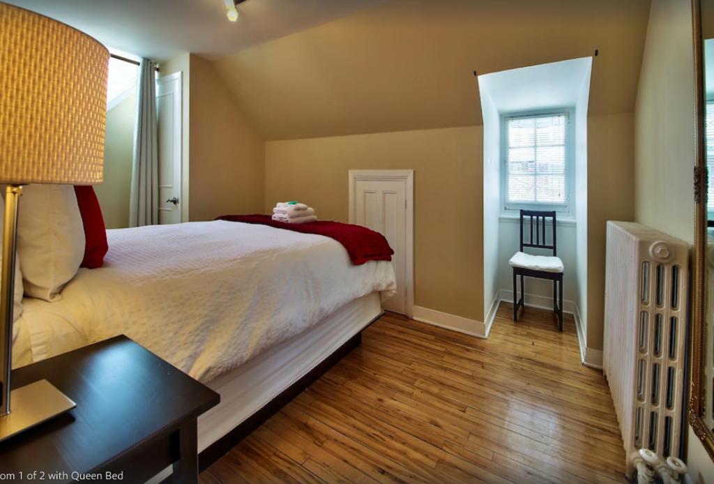 1 dormitorio con cama, mesa y ventana en Les Maisons Montcalm, en Quebec