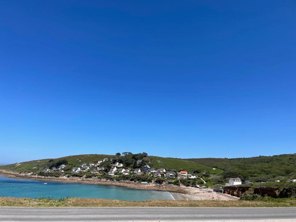 una ciudad en una colina junto a un cuerpo de agua en Au Petit Brick - Cosy beachfront house en Maupertus-sur-Mer