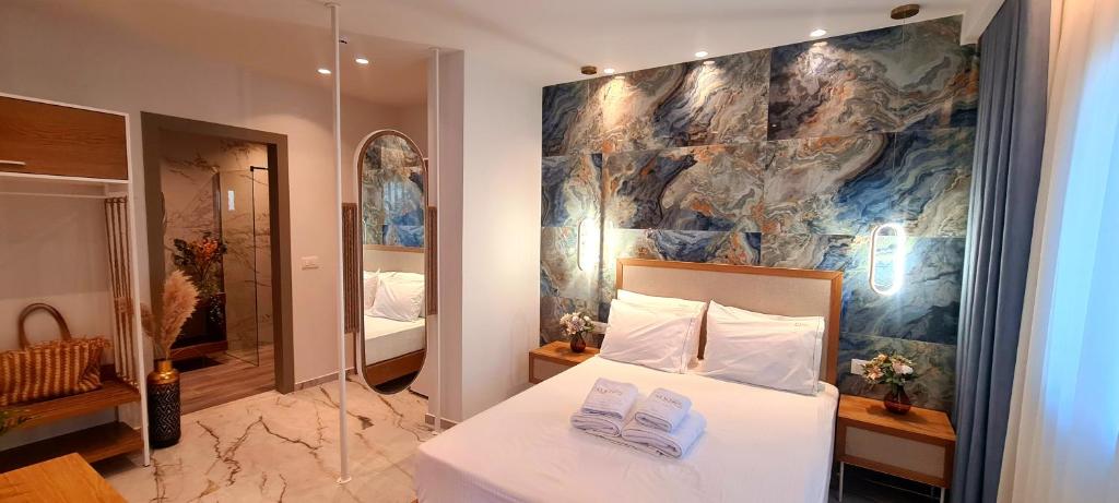 een slaapkamer met een bed en een schilderij aan de muur bij Costa ANASTASIA_sea view suites in Nea Vrasna