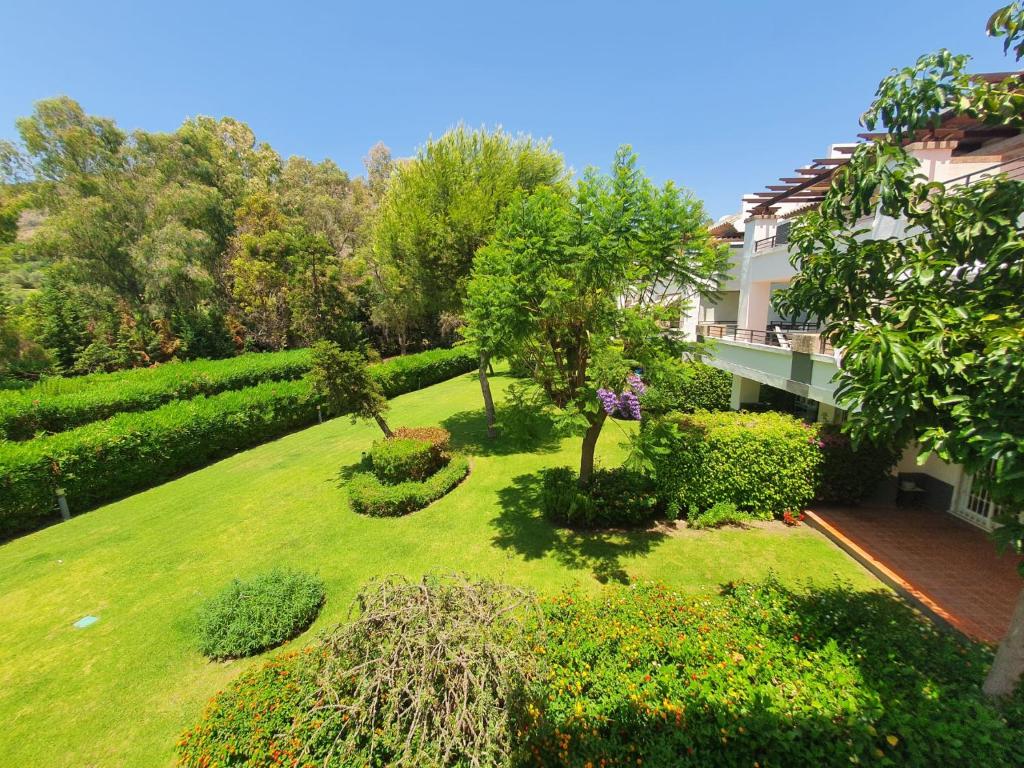 een luchtzicht op een tuin met een huis bij Los Arqueros Golf lovely condo near Marbella & Puerto Banus in Benahavís