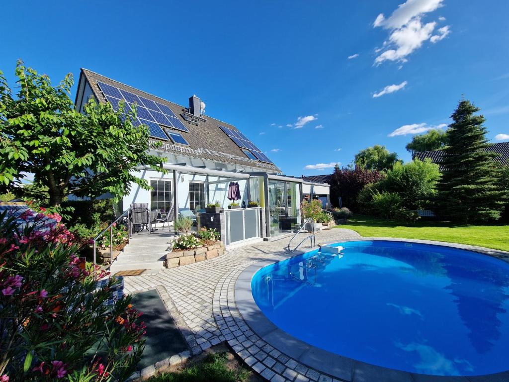 Eilenburg的住宿－Ferienwohnung Heinze，庭院中带游泳池的房子