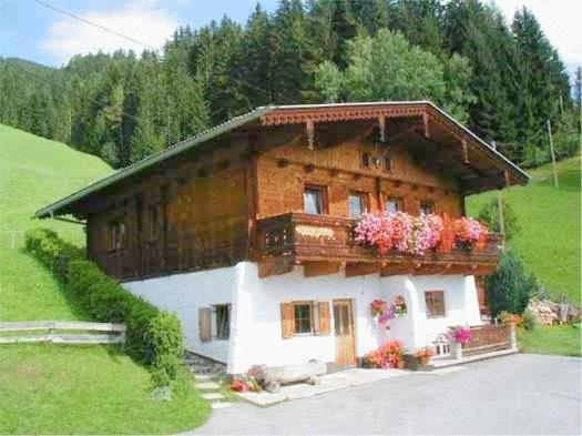 dom z kwiatami na balkonie w obiekcie Appartementhaus Eberharter w mieście Hart im Zillertal