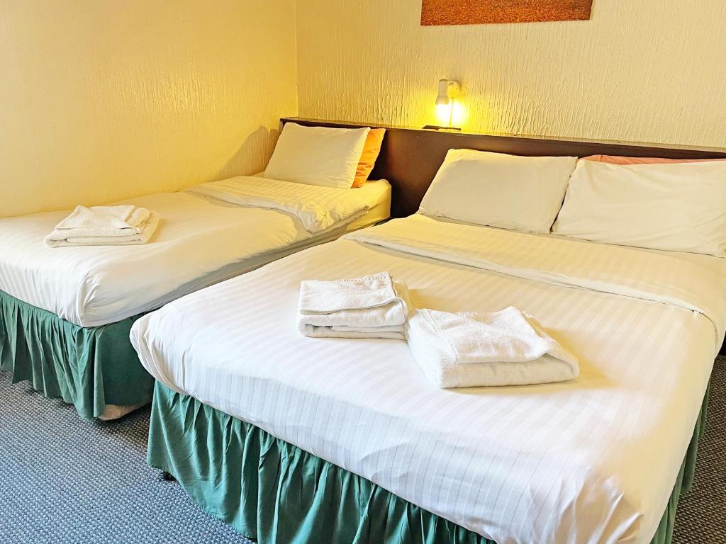 2 Betten in einem Hotelzimmer mit Handtüchern darauf in der Unterkunft Balin Helmshore in Blackpool