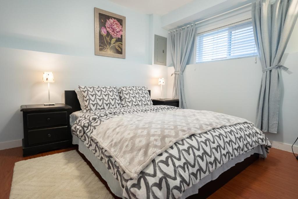 a bedroom with a black and white bed and a window at Lovely 1BR Secondary suite with Separate entrance in New Westminster