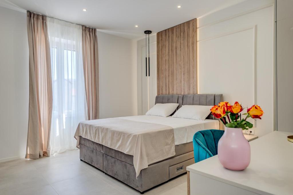a bedroom with a bed and a vase of flowers on a table at 48 Luxury Apartment Split in Split