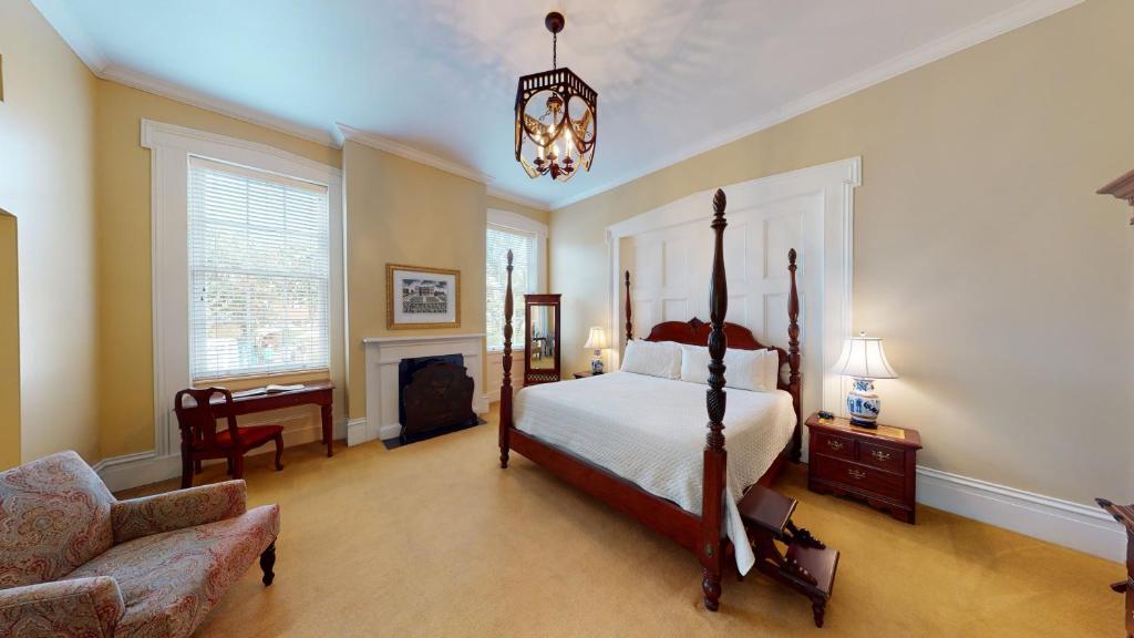 a bedroom with a bed and a chair and a chandelier at The Presidents' Quarters Inn in Savannah