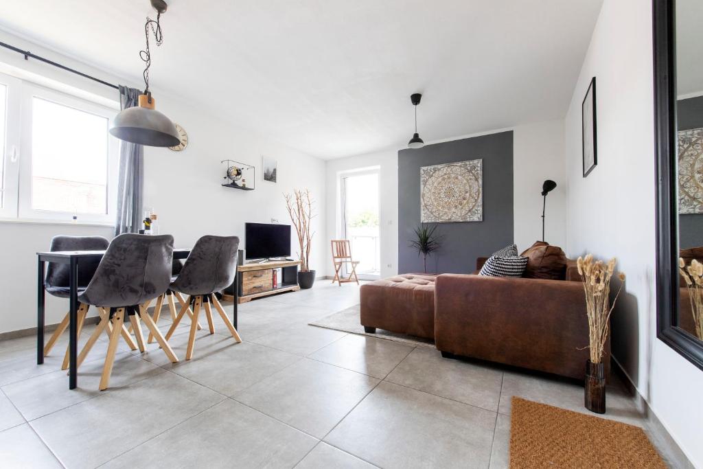 een woonkamer met een bank en een tafel en stoelen bij Luxus Apartment Gronau - direkte Nähe zu Enschede in Gronau