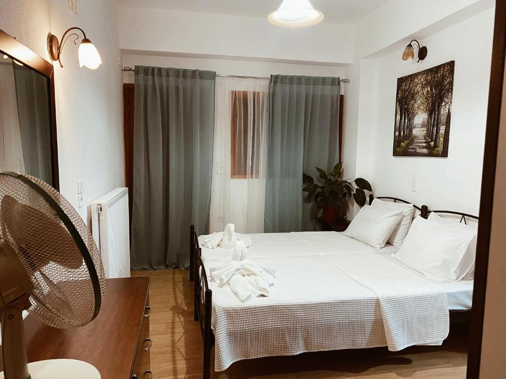 una camera con due letti con lenzuola bianche di Andreas Village 2 ad Achladies