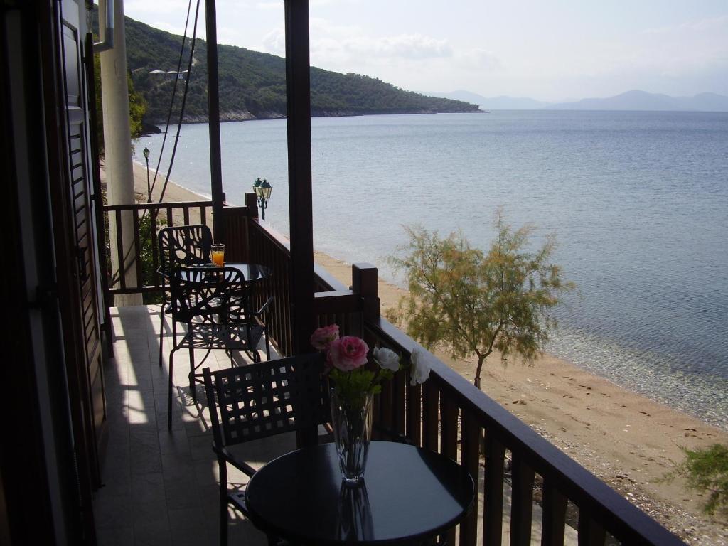 un balcón con sillas y una mesa con un jarrón de flores en Sunset Suites, en Lefokastro