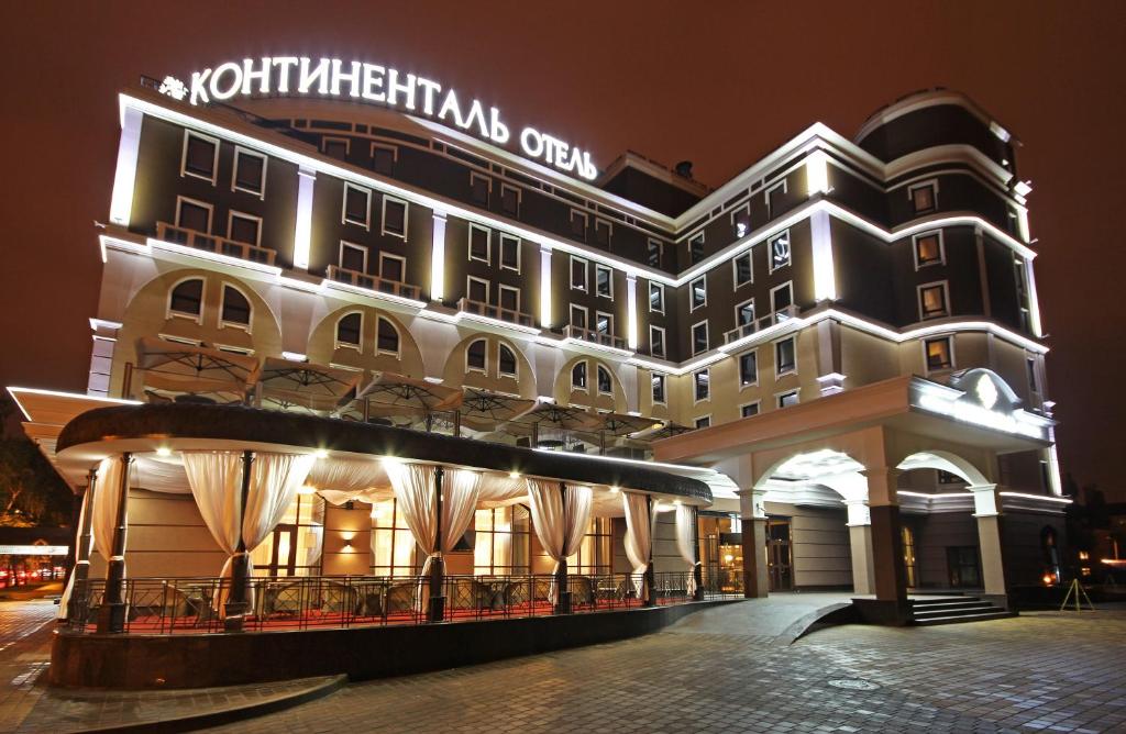 a large building with a sign on it at night at Business Hotel Continental in Belgorod