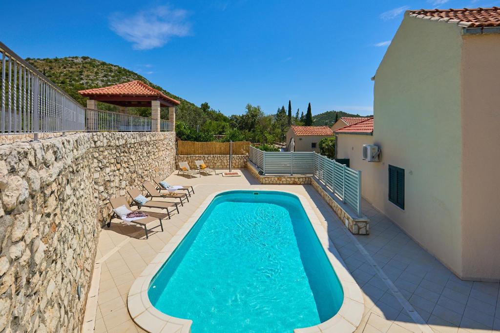 una piscina junto a una pared de piedra en Hedera Estate, Villa Hedera IX en Banići