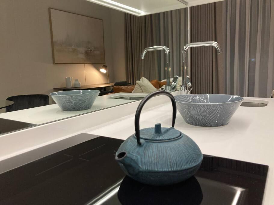 a kitchen with two sinks and two bowls on a counter at Luxury Apartment at Ellipse Waterfall, Midrand Near Mall of Africa in Midrand