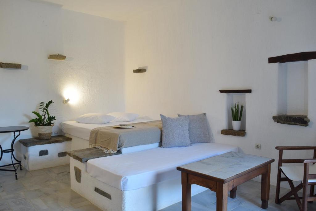 a bedroom with two beds and a table and chairs at Sunset Pounda in Pounda