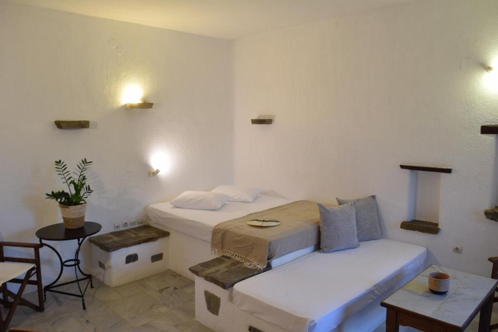a bedroom with two beds and a table and chairs at Sunset Pounda in Pounda